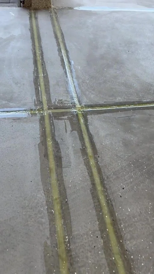 Garage floor during work, with visible joint lines and coated perimeter